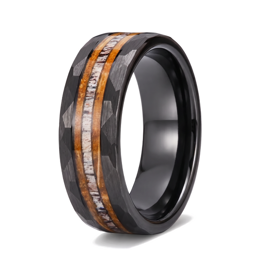 The Cooper black hammered tungsten ring with whiskey barrel wood and deer antler inlay on a white background