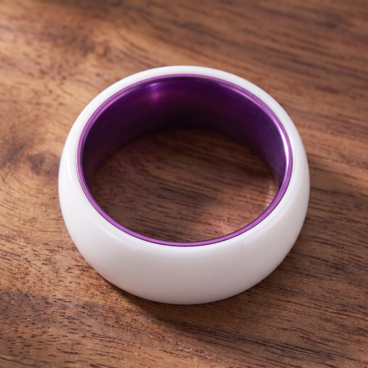 The Prism white ceramic ring lying flat showing the purple interior