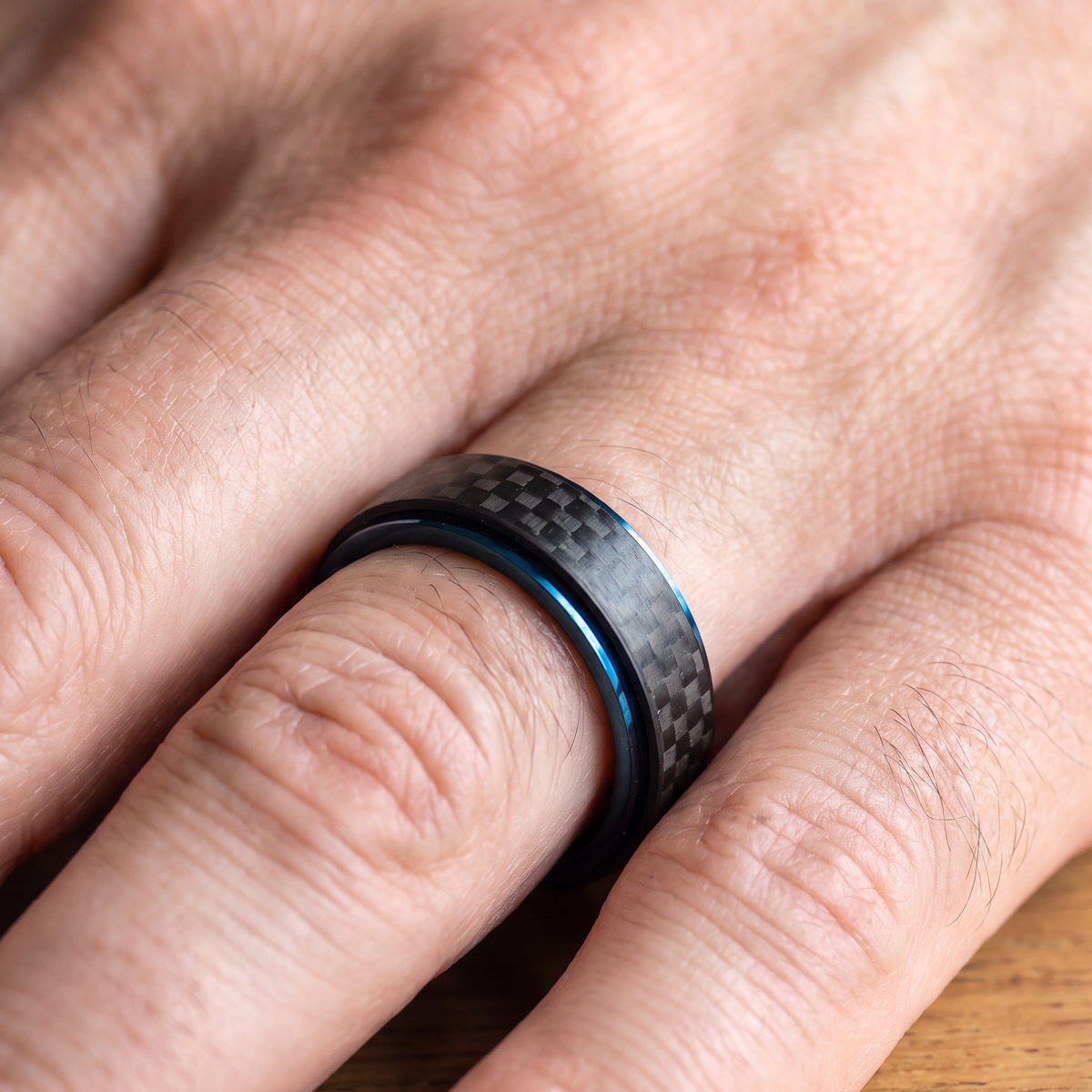 Close up of a man's hand wearing The Spinner carbon fiber ring