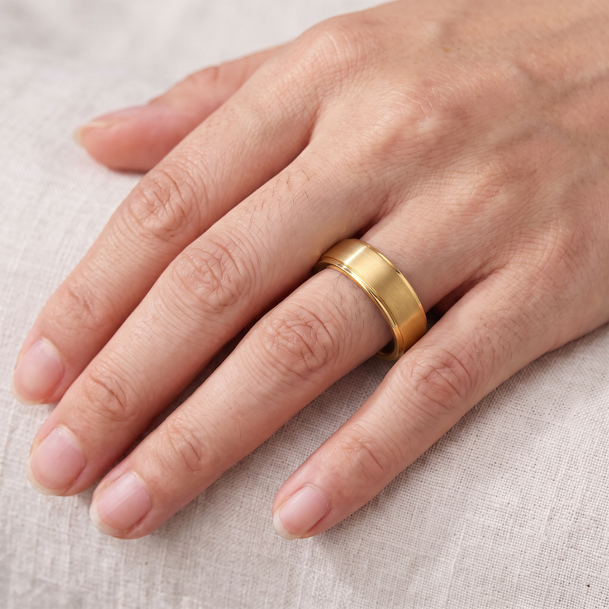 Close up of a woman's hand wearing The Corona gold color tungsten ring
