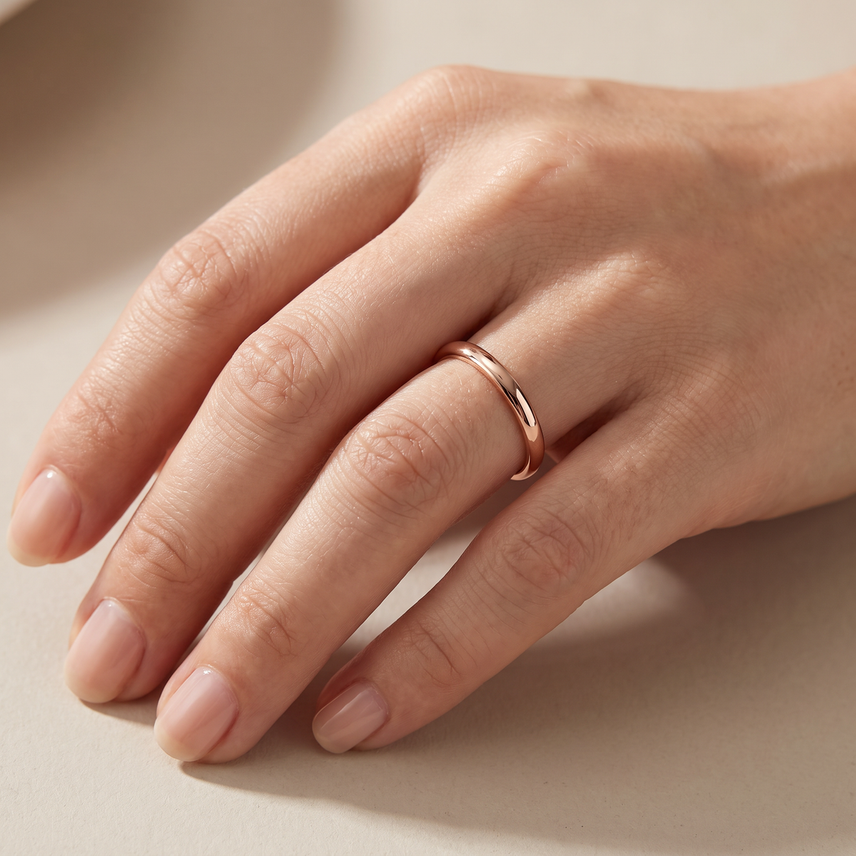 Close up of a woman's hand wearing The Filament rose color tungsten ring