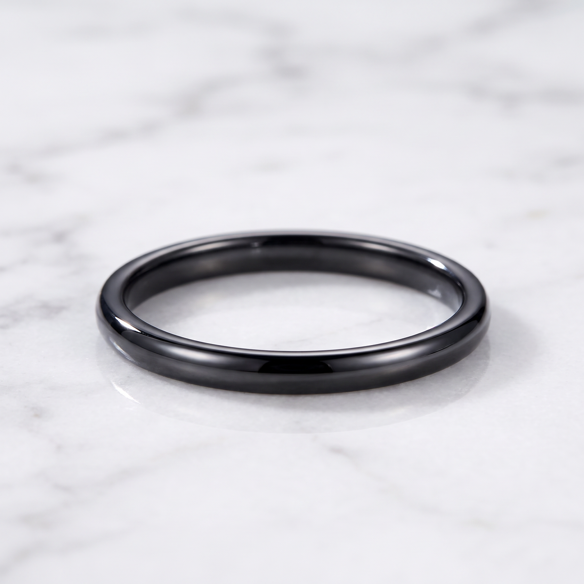 The Filament black tungsten ring lying flat on white marble