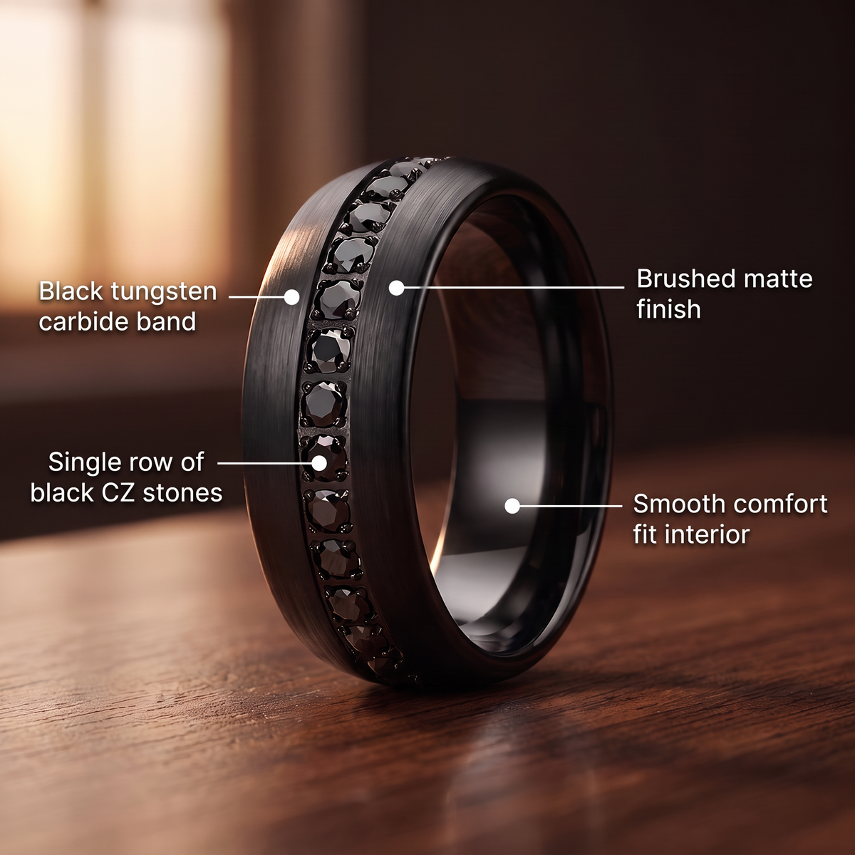 The Obsidian ring on a walnut table with callouts for black tungsten carbide band, single row of black CZ stones, brushed matte finish and smooth comfort fit interior