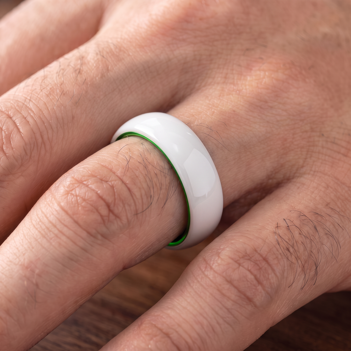 The Prism white ceramic ring with green interior worn on a hand