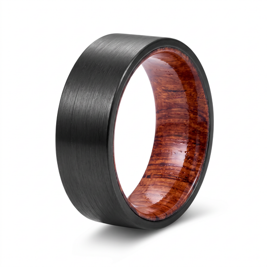 The Ember ring with a black brushed tungsten carbide outer band and a koa wood interior on a white background