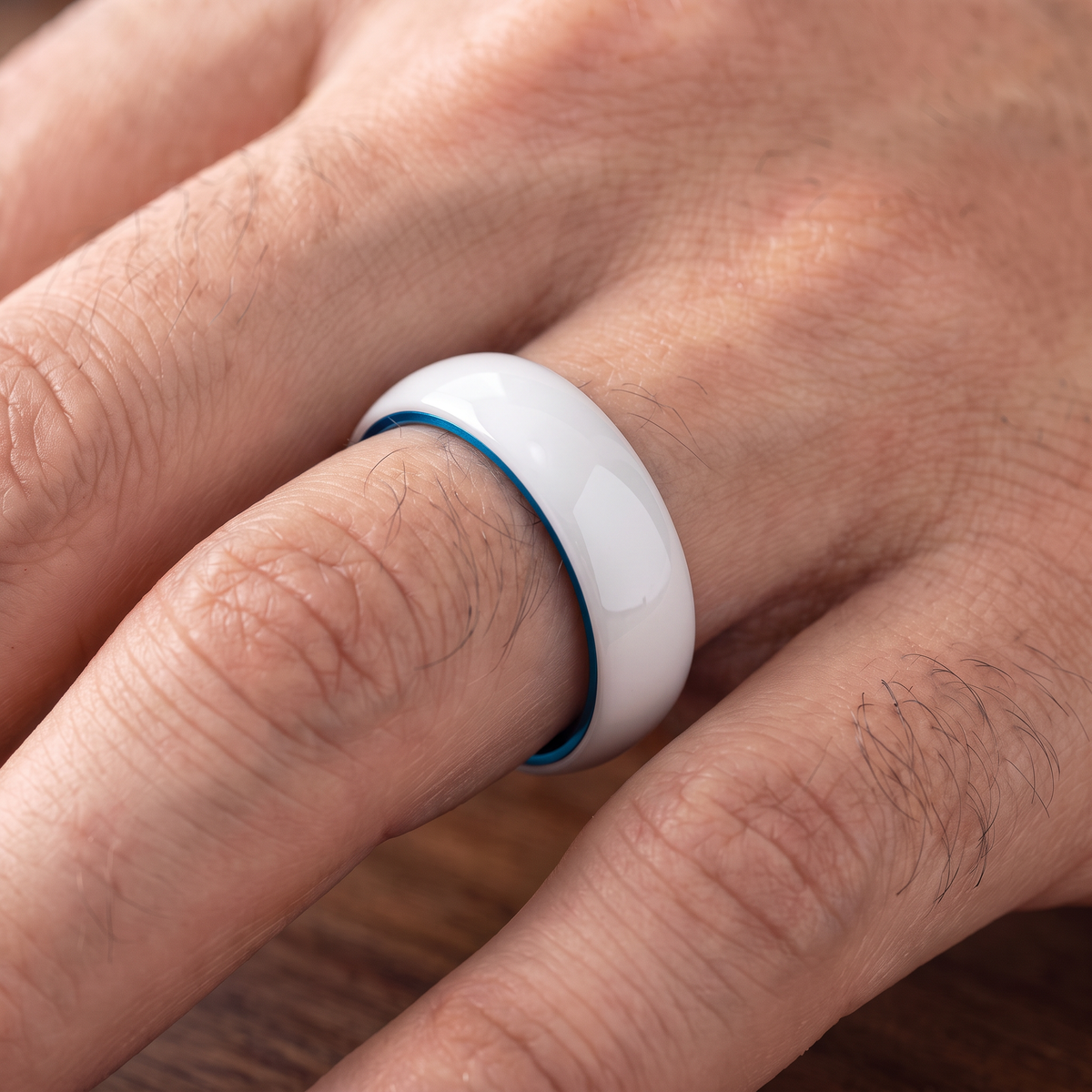 The Prism white ceramic ring with blue interior worn on a hand