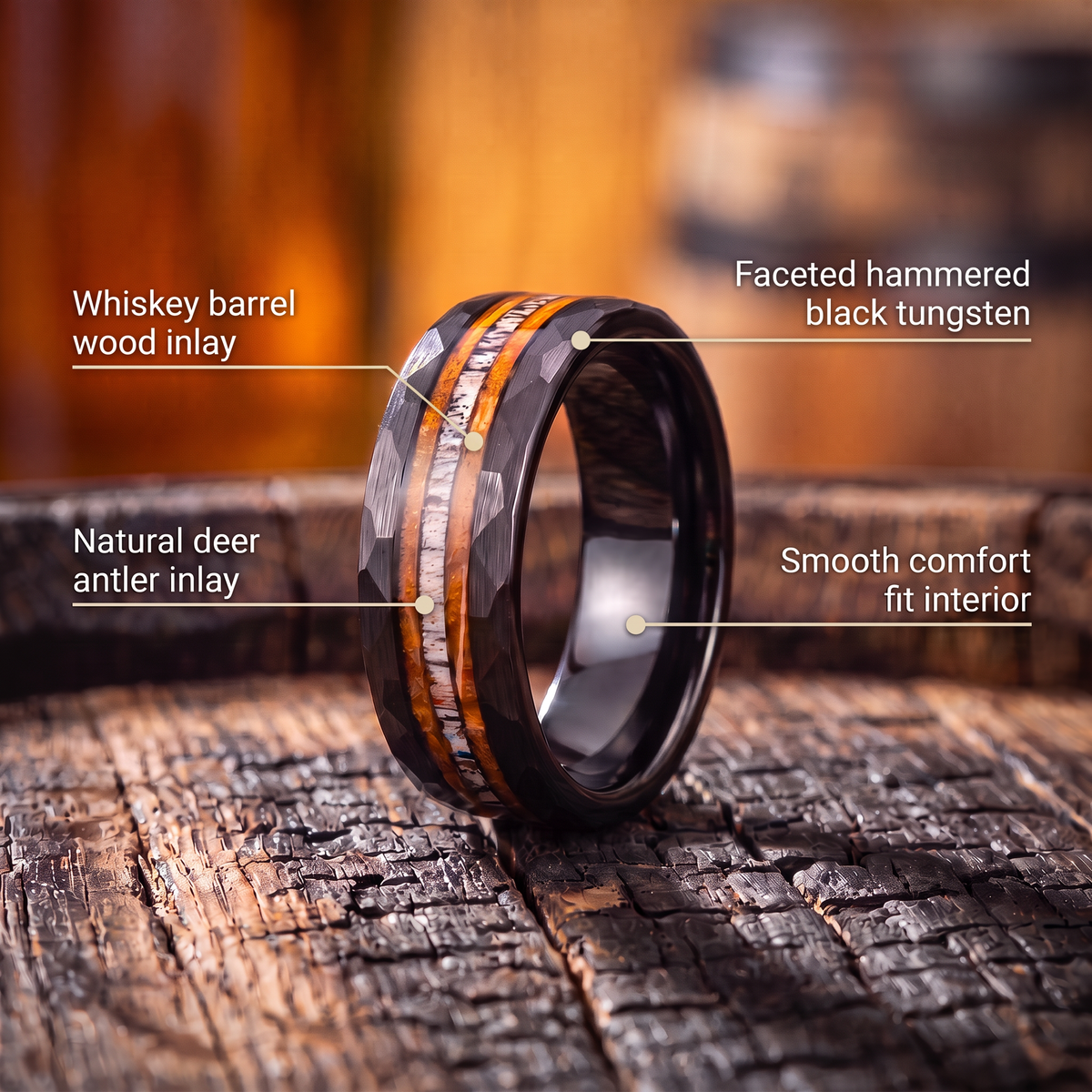 The Cooper ring on a charred whiskey barrel with callouts for barrel wood inlay, deer antler inlay, faceted hammered black tungsten and comfort fit interior