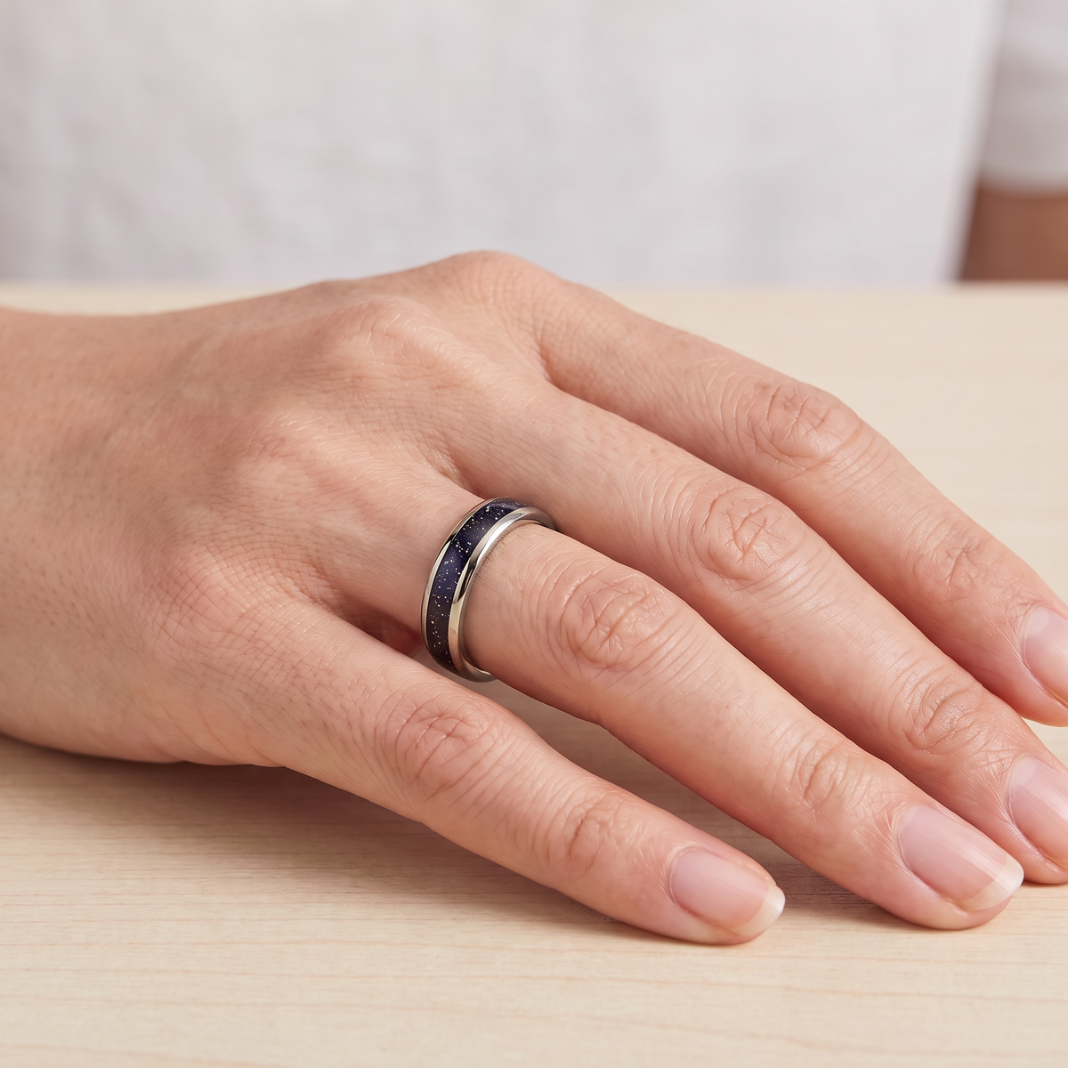 Close up of a woman's hand wearing The Vega silver color tungsten ring with a galaxy opal inlay