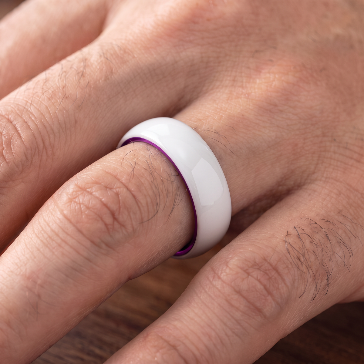 The Prism white ceramic ring with purple interior worn on a hand