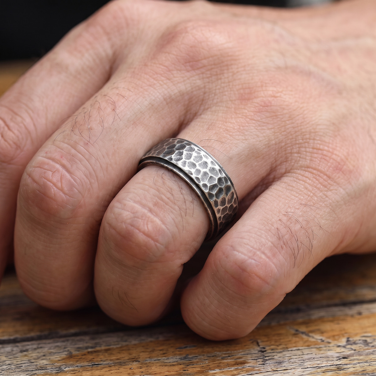 Close up of a man's hand wearing The Crater antique hammered ring