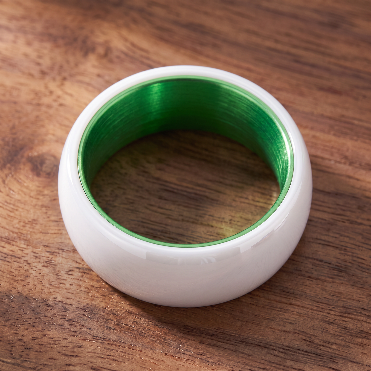 The Prism white ceramic ring lying flat showing the green interior