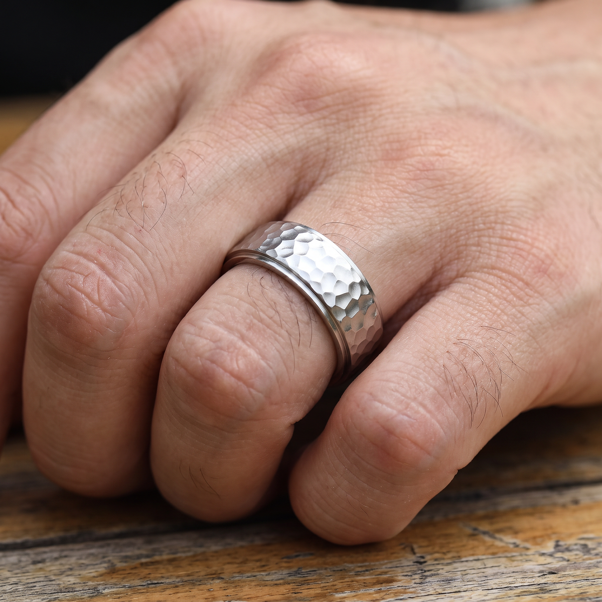 Close up of a man's hand wearing The Crater silver hammered ring