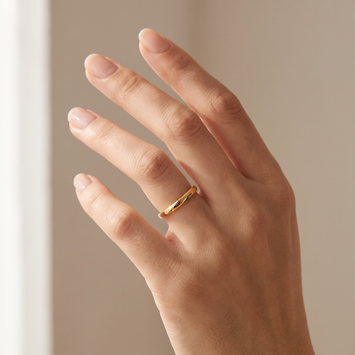 Close up of a woman's hand wearing The Filament gold color tungsten ring