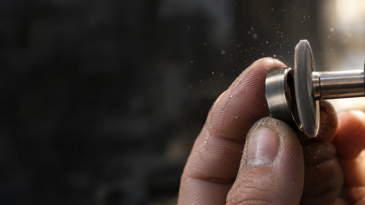 Hands finishing a tungsten ring