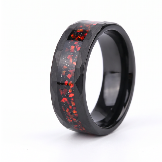 The Magma black hammered tungsten ring with a red opal inlay on a white background