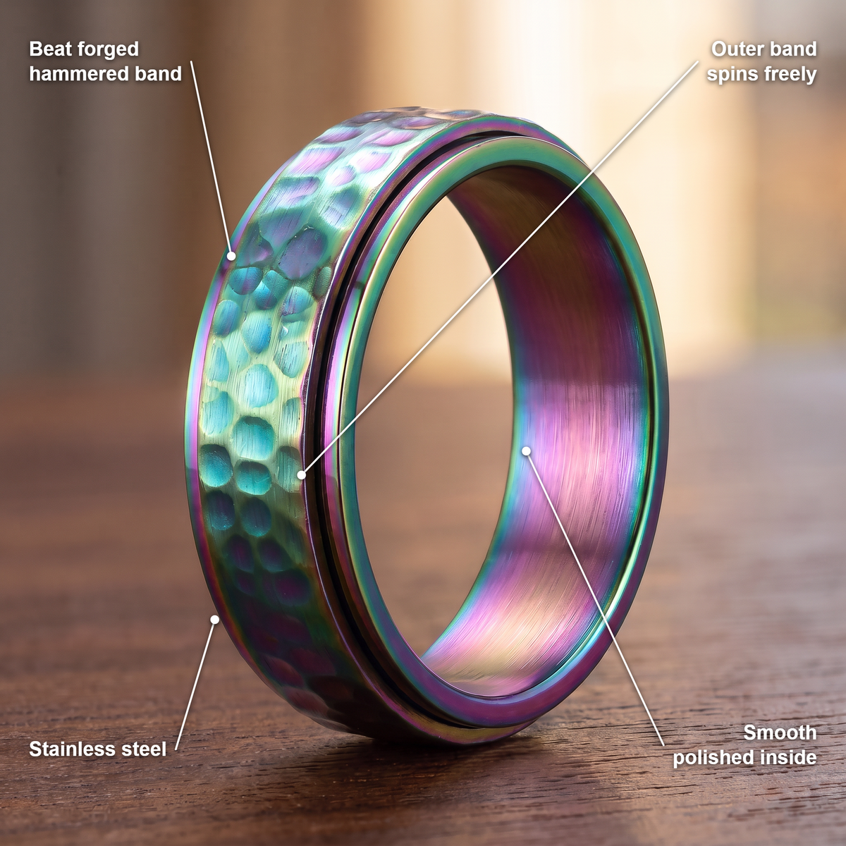 The Orbit ring details in rainbow: beat forged hammered band, outer band spins freely, stainless steel, smooth polished inside