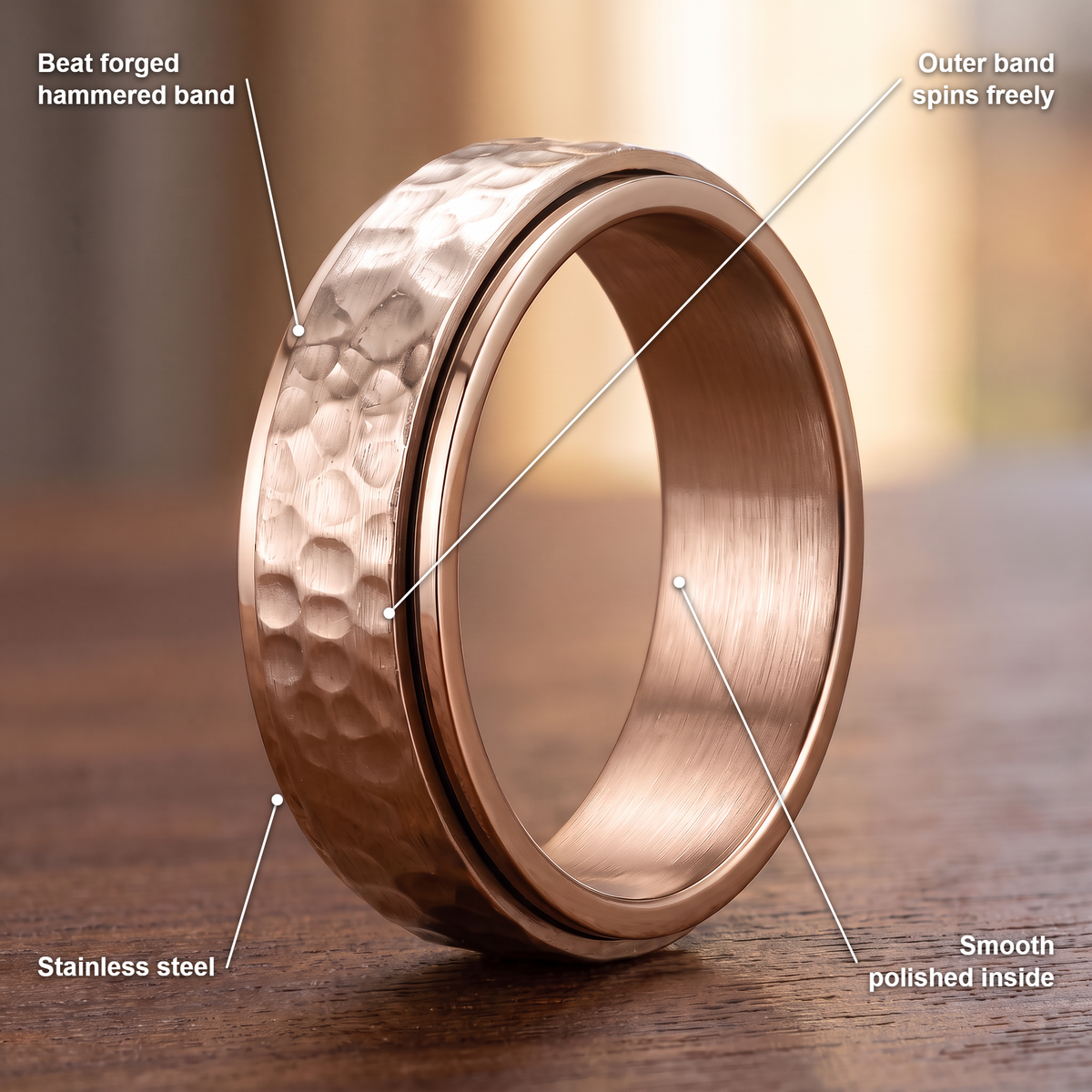 The Orbit ring details in rose: beat forged hammered band, outer band spins freely, stainless steel, smooth polished inside
